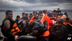 FILE - Refugees and migrants arrive on a beach after crossing a part of the Aegean sea from the Turkey's coast to the Greek island of Lesbos, Nov. 28, 2015.