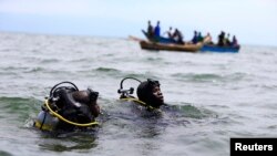 Des membres de la police ougandaise participent à des opérations de sauvetage après le chavirement d'un bateau transportant principalement des réfugiés congolais sur le lac Albert, au sud-ouest de la capitale ougandaise, Kampala, le 23 mars 2014.