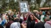 FILE - Relatives mourn as they lift portraits of family members they lost in the collapse of a mountain of trash at a garbage dump, during a funeral service held at Gebrekristos church in Addis Ababa, Ethiopia, March 13, 2017.