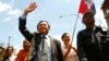 Cambodia's main opposition Cambodia National Rescue Party Vice President Kem Sokha, center, waves during a protest rally in Phnom Penh, Cambodia, May 20, 2013. 