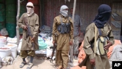 FILE - Armed Al-Shabab fighters patrol in Mogadishu, Somalia, June 29, 2009. 