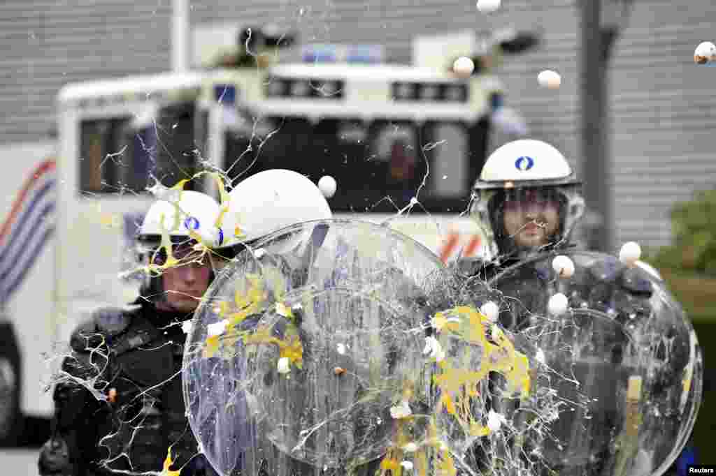 Policemen are hit by eggs as farmers and dairy farmers from all over Europe take part in a demonstration,&nbsp;calling for more help with low prices and high costs, outside a European Union farm ministers&#39; emergency meeting at the EU Council headquarters in Brussels, Belgium, Sept. 7, 2015.