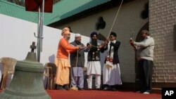 An old bell that was removed is seen in foreground as people from various faiths including Muslims, Hindus and Sikhs ring the new bell during its installation at the Holy Family Catholic Church in Srinagar, Indian controlled Kashmir, Oct. 29, 2017.