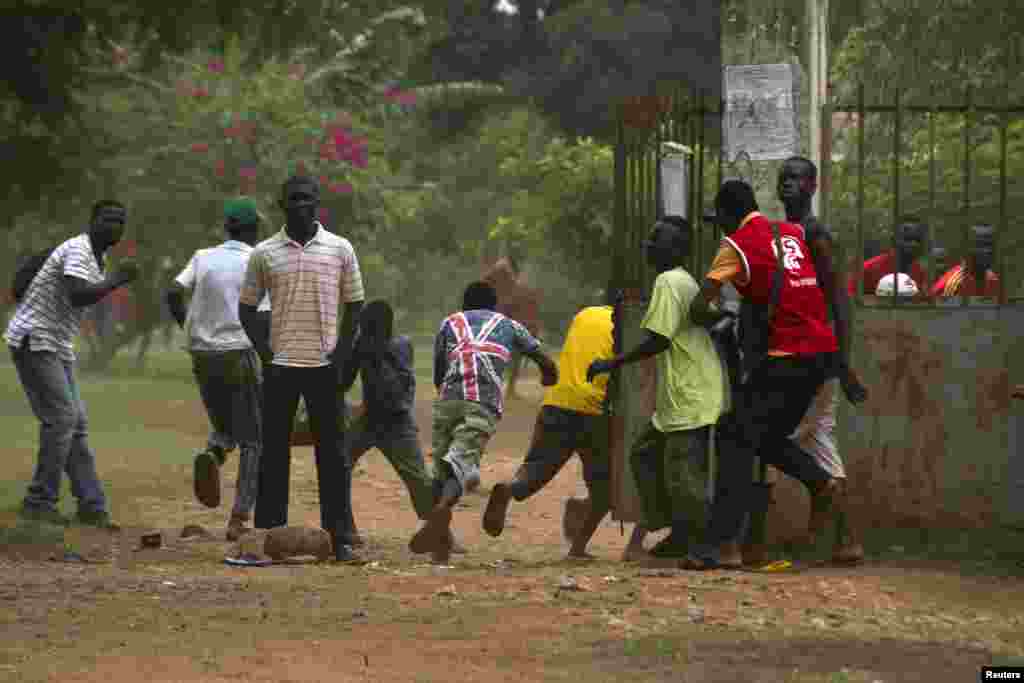 A crowd runs for cover as AU peacekeeping soldiers fire warning shots to disperse a crowd near Miskine, Bangui, Feb. 7, 2014.