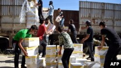 Warga Suriah membawa bantuan kemanusiaan yang disediakan oleh PBB, World Food Program (WFP) dan Bulan Sabit Merah Arab Suriah di kota yang dikuasai pemberontak di pinggiran Homs di Suriah pusat, 25 Mei 2016. (Foto: dok.)