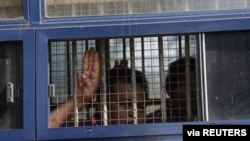 A man flashes the three-finger salute after being arrested during a protest against the military coup in Mawlamyine, Myanmar, Feb. 12, 2021. (Than Lwin Times/Handout via Reuters)