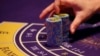 FILE - a croupier counts the chips at a baccarat gaming table inside a casino during the opening day of Sheraton Macao Hotel at the Sands Cotai Central in Macau.