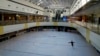 A woman wearing a face mask practices freestyle skating in an ice rink normally crowded with skaters in a shopping mall in Beijing, Sunday, Dec. 18, 2022. 