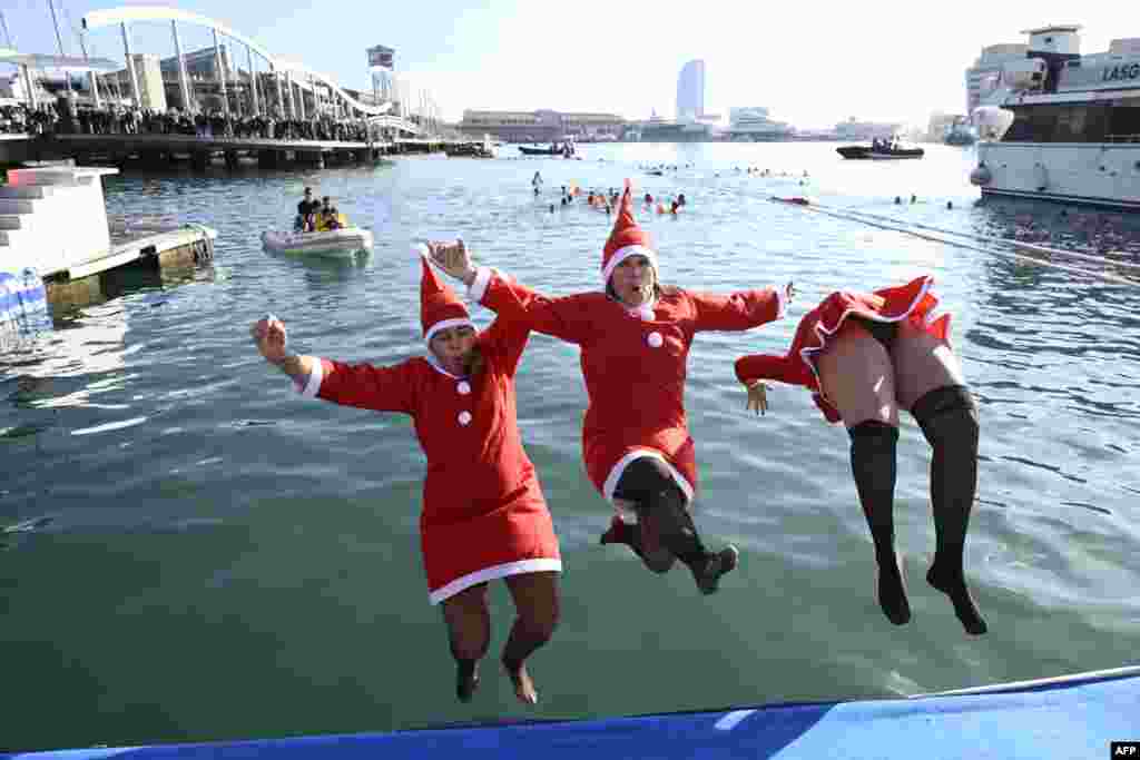 Participants in Santa costumes jump into the water during the 115th edition of the Copa Nadal (Christmas Cup) swimming race in Barcelona's Port Vell, Spain, Dec. 25, 2024.