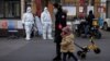 Guards in protective suits keep watch at the gate to a residential compound as coronavirus disease (COVID-19) outbreaks continue in Beijing, Dec. 7, 2022. 