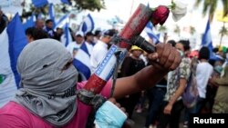 Seorang pengunjuk rasa berpose dengan mortir buatan sendiri dalam sebuah unjuk rasa menentang pemerintahan Presiden Daniel Ortega di Managua, Nikaragua, 30 Mei 2018 (foto: REUTERS/Oswaldo Rivas)