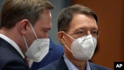 German Health Minister Karl Lauterbach, right, stands next to German Finance Minister Christian Lindner, left, in Berlin, Germany, Dec. 13, 2021.