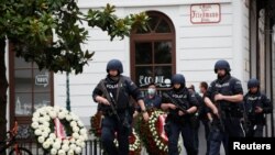 Police officers walk at the site of wreath laying ceremony after exchanges of gunfire in Vienna, Austria, Nov. 3, 2020. 
