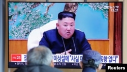 People watch a TV broadcasting a news report on North Korean leader Kim Jong Un in Seoul, South Korea, April 21, 2020.