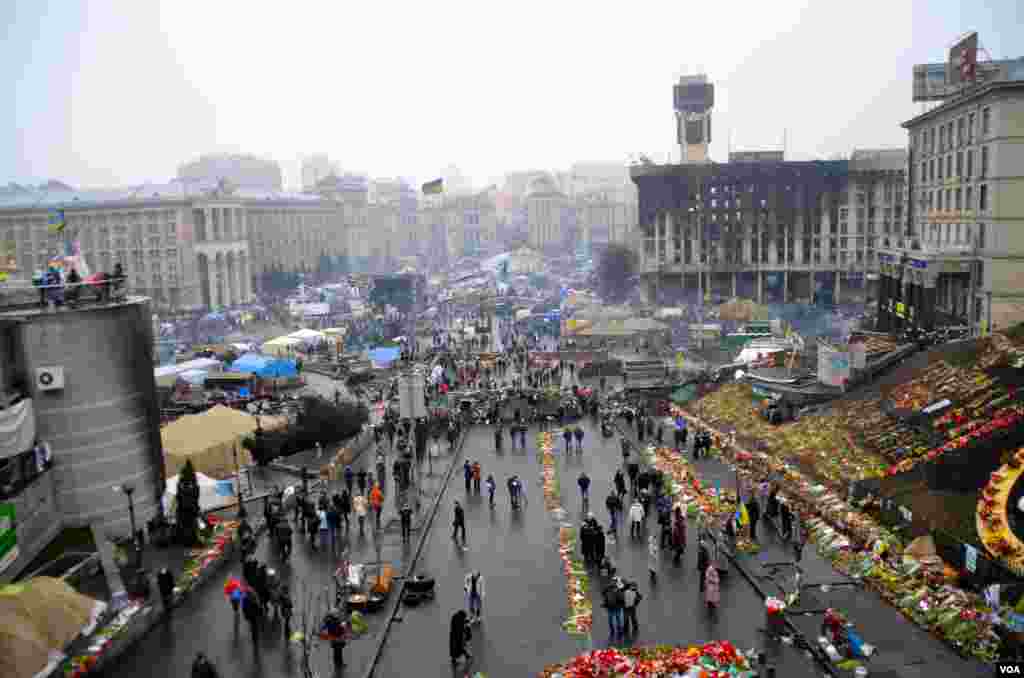 People look at flowers placed in Kyiv's Independence Square in memory of anti-government protesters killed during recent clashes, Mar. 8. 2014. (Jamie Dettmer/VOA)