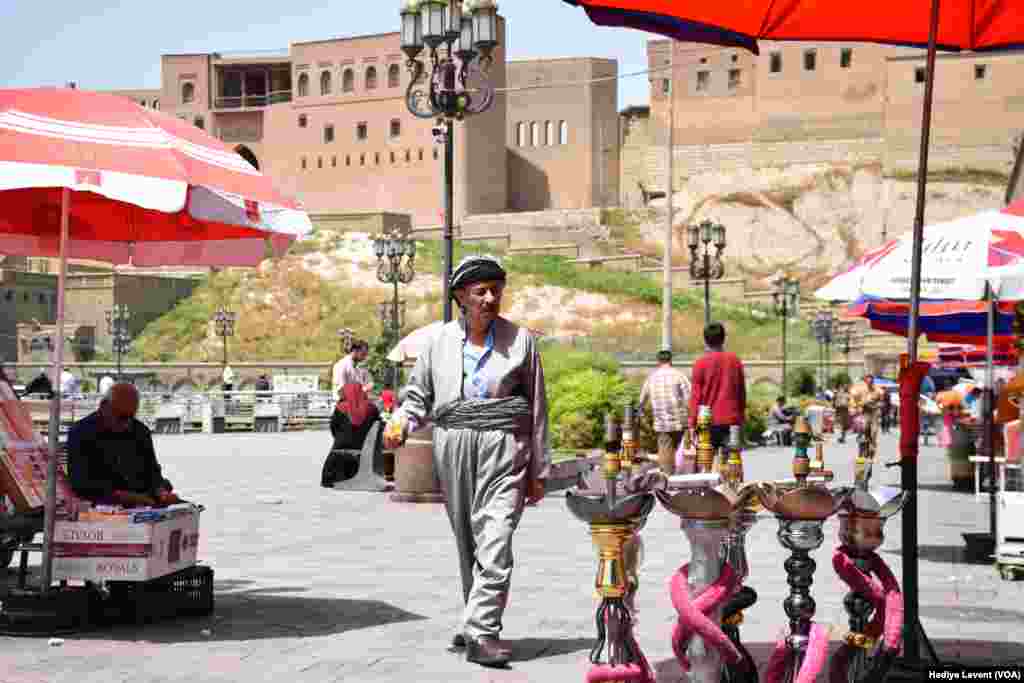 Wani mutum yana tafiya a cikin wata &#39;yar karamar kasuwa dake garin Irbil