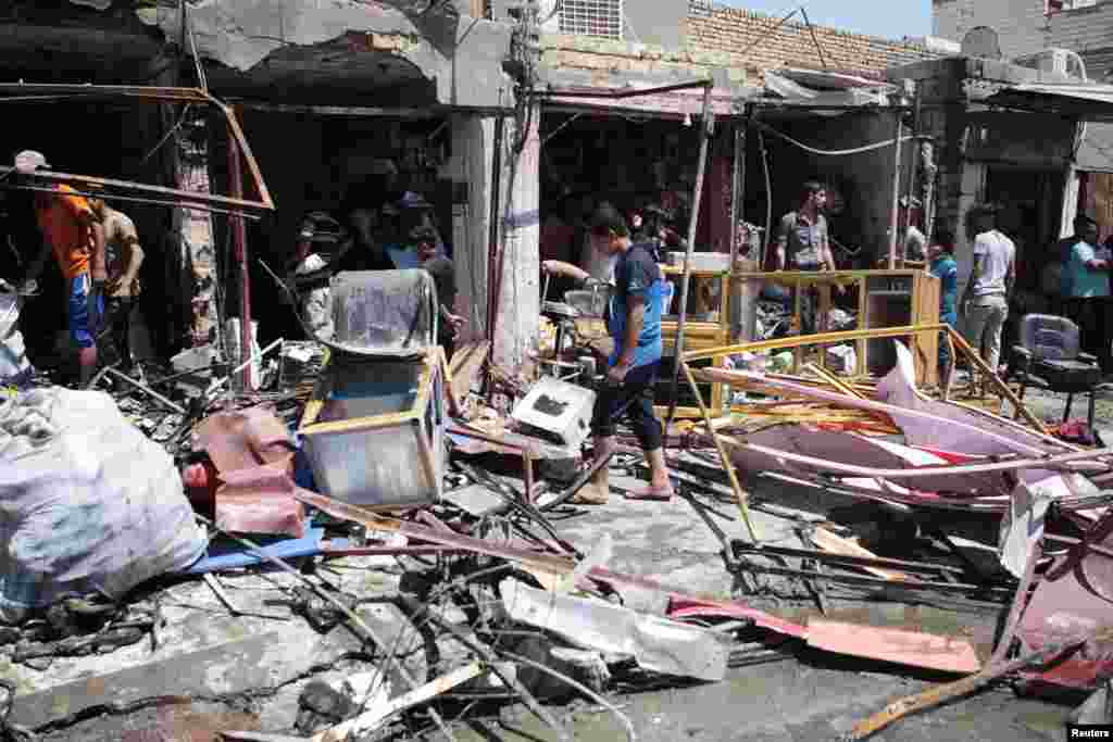 Residents inspect the site of a car bomb attack in Basra, Iraq, July 29, 2013.&nbsp;