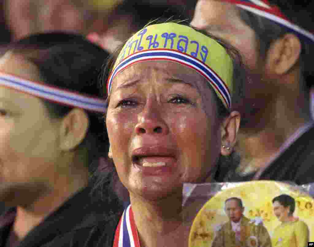 Holding a picture of Thai King Bhumibol Adiulyadej and Queen Sirikit, an anti-government protester cries during a demonstration in Bangkok, Nov. 11, 2013. 