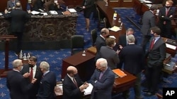 Arhiva - Republikanski senatori i osoblje Kongresa razgovaraju u sali za sjednice u pauzi drugog suđnja za opoziv predsjednika Donalda Trumpa u Senatu, na Kapitolu, 13. februara 2021. (Senate Television via AP)