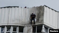 Radnici popravljaju štetu na krovu višespratnog stambenog bloka nakon prijavljenog napada dronom u Moskvi, Rusija, 30. maja 2023. REUTERS
