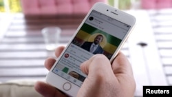 FILE - A man scrolls down his cellphone for a social media newsfeed about Ethiopian Prime Minister Abiy Ahmed winning the Nobel Peace Prize in Addis Ababa, Ethiopia, Oct.11, 2019. 