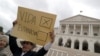 Seorang demonstran mengacungkan poster dalam protes menentang eutanasia di depan parlemen Portugal, di Lisbon, Portugal, 29 Mei 2018. (Foto: Reuters)