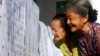 Perempuan lanjut usia mengecek daftar nama caleg di TPS di Bali, Rabu 9 April 2014. (Foto: AP/Firdia Lisnawati)