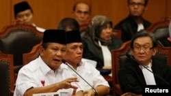 Kandidat presiden Indonesia yang kalah Prabowo Subianto (kiri) menyampaikan keterangan pads Mahkamah Konstitusi bersama pasangannya Hatta Rajasa (tengah) di Jakarta, 6 Agustus 2014.