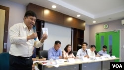 លោក ​សួន ប៊ុនស័ក្តិ​ នាយក​លេខាធិការដ្ឋាន​នៃ​គណៈកម្មាធិការ​ប្រព្រឹត្តិកម្ម​នៃ​អង្គការ​សមាគមការពារ​សិទ្ធិ​មនុស្ស​កម្ពុជា ​លើក​កាន់​រដ្ឋធម្មនុញ្ញ​កម្ពុជា​ ក្នុង​អំឡុង​​​សន្និសីទ​​ព័ត៌មាន​អំពី​យុទ្ធនាការ​​«ឈប់​និង​ពិគ្រោះ​យោបល់​លើ​ច្បាប់​​ស្តី​ពី​សមាគម​និង​អង្គការ​មិនមែន​រដ្ឋាភិ​បាល» កាល​ពី​ថ្ងៃ​ច័ន្ទ​ទី​៤ ខែ​ឧសភា ឆ្នាំ​២០១៥។ (រូបថត៖ នៅ វណ្ណារិន/VOA)