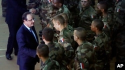 Presiden Perancis Francois Hollande (kiri) saat meninjau pasukan Perancis yang ditempatkan di Bangui, Republik Afrika Tengah (Foto: dok). Empat belas tentara Perancis sedang diselidiki atas tuduhan melakukan pelanggaran terhadap anak-anak di Republik Afrika Tengah tahun lalu.