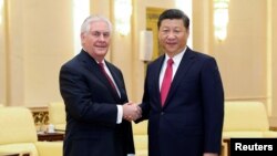 លោក​ប្រធានាធិបតី​ចិន Xi Jinping ចាប់​ដៃ​លោក​រដ្ឋ​មន្រ្តី​ការបរទេស​អាមេរិក Rex Tillerson នៅ​មុន​កិច្ចប្រជុំ​របស់​លោក​នៅ​ក្នុង​វិមាន Great Hall of the People កាលពី​ថ្ងៃទី១៩ ខែមីនា ឆ្នាំ២០១៧ ក្នុង​ក្រុង​ប៉េកាំង ប្រទេស​ចិន។