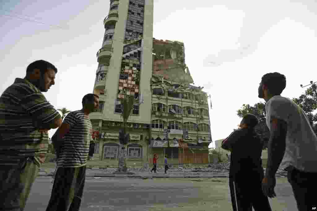 Palestinians inspect the damage of the Al-Shalam (Peace) tower, destroyed by an overnight Israeli strike, in Gaza City, July 22, 2014. 