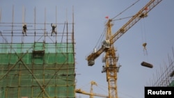 Ouvriers sur un chantier de construction dans une zone industrielle à Beijing, Chine, le 14 Avril 2016.