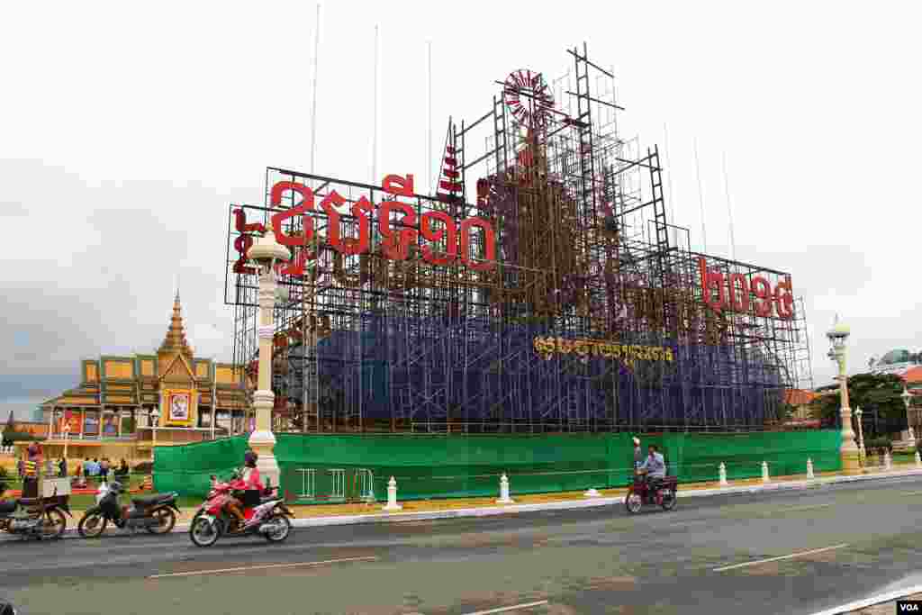 ការ​រៀប​ចំ​តុប​តែ​ង​លម្អ​នៅ​មុខ​ព្រះ​បរម​រាជវាំង​ក្នុង​រាជធានី​ភ្នំពេញ ដើម្បី​អប​អរ​ថ្វាយ​ព្រះ​ពរ​ខួប​ទី​១០​នៃ​ព្រះរាជ​ពិធី​គ្រង​រាជ​សម្បត្តិ​របស់​ព្រះបាទ​សម្ដេច​ព្រះបរមនាថ នរោត្តម សីហមុនី នៅ​ថ្ងៃទី ២៥ ខែតុលា ឆ្នាំ២០១៤។ (នូវ ពៅលក្ខិណាVOA)