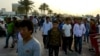 FILE - Migrant workers walk on the corniche in Doha, Qatar, April 14, 2017. 