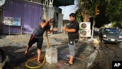 People cool themselves with water in central Baghdad, Iraq, July 16, 2015. The government declared Thursday an official holiday due to scorching temperatures. 