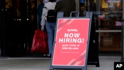FILE - A hiring sign is displayed outside of a retail store in Vernon Hills, Illinois, Nov. 13, 2021.
