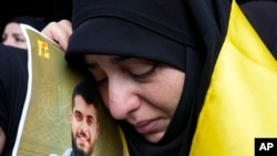 Yoon dam kenbe foto yon manm Hezbollah ki te mouri Mekredi apre yon aparey elektwonik li tap itilize te eksploze, 19 Sept. 2024.