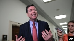 FILE - Former FBI Director James Comey speaks to reporters on Capitol Hill Washington, Dec. 17, 2018.