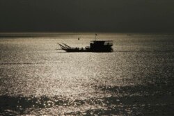 FILE - A ferry transports people from Phnom Penh to Arey Ksat across the Mekong River outside Phnom Penh, Cambodia, Jan. 28, 2020.