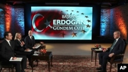 Turkey's President Recep Tayyip Erdogan, right, speaks during an interview with private A Haber and ATV television channels, in Istanbul, Turkey, Dec. 15, 2019.