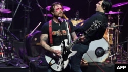 Jesse Hughes (L), the singer of US rock group Eagles of Death Metal, performs on stage at the Olympia concert hall in Paris, Feb. 16, 2016. 
