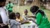 Seorang petugas memberikan pengarahan bagaimana cara mencuci tangan dengan benar untuk anak-anak di pintu masuk Rumah Sakit Mbagathi di Nairobi, Kenya, 18 Maret 2020. (Foto: dok).