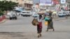 Des vendeurs portent les leurs produits, dans les rues de Bujumbura, le 3 février 2016.