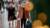 Seorang perempuan, yang mengenakan masker untuk menjaga diri dari infeksi COVID-19, membawa beberapa kantong belanjaan ketika berjalan melalui Oxford Street di London, pada 27 Desember 2021. (Foto: AP/David Cliff)