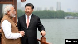 India's Prime Minister Narendra Modi speaks with Chinese President Xi Jinping as they take a boat ride on the East Lake in Wuhan, China, April 28, 2018. 