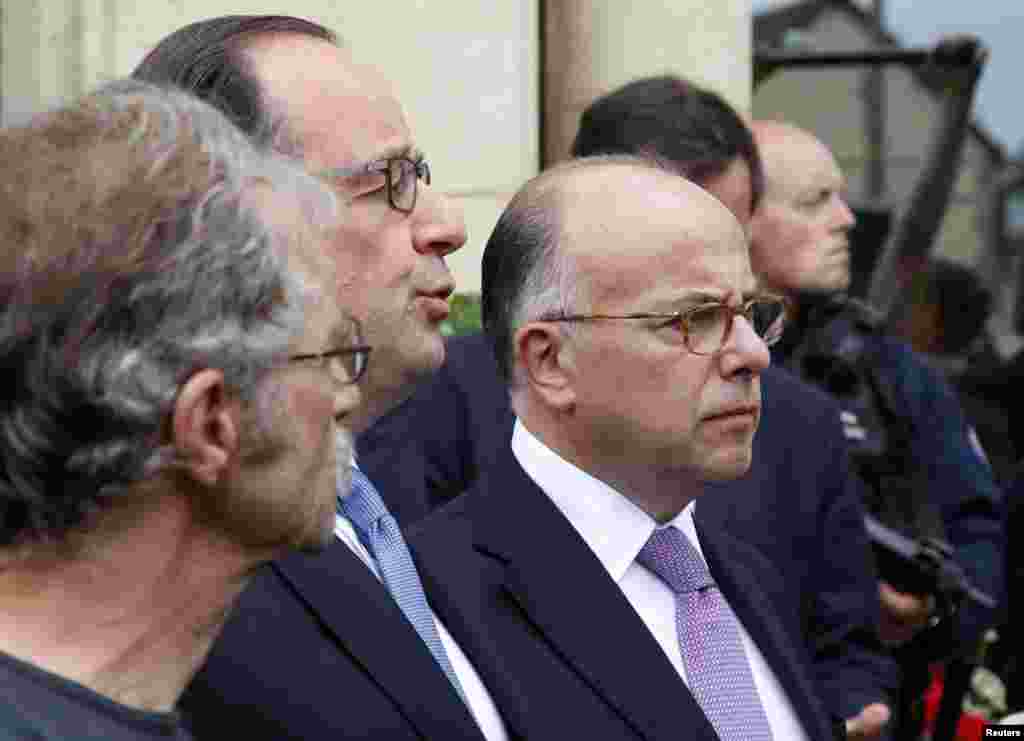 French President Francois Hollande (C) and Interior Minister Bernard Cazeneuve (R) speak to journalists in front of the city hall after two assailants had taken five people hostage in the church at Saint-Etienne-du -Rouvray near Rouen in Normandy, France on July 26, 2016.&nbsp;