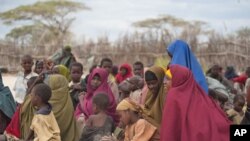 Mothers sit with their children in a compound for internally displaced persons in the Somali border town of Dhobley, August 11, 2011.