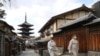 Dua perempuan berjalan di tengah keadaan darurat akibat wabah Covid-19 di Kyoto, Jepang 13 Januari 2021. (Foto: Kyodo via REUTERS)