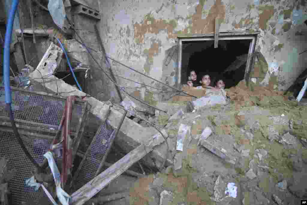 Watoto wakipalestina wakiangalia jengo la familia ya Zanon lililobomolewa kutokana na mashambulizi ya ndege mji wa Rafah kwenye ukanda wa Gaza. Oktoba 14, 2023.